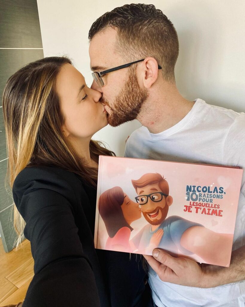 A couple kissing while holding a personalised book for couples.