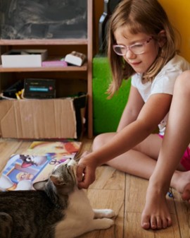 A girl with a personalised book for kids and cats.