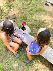 Two children reading a Hooray Heroes personalised siblings book together. 