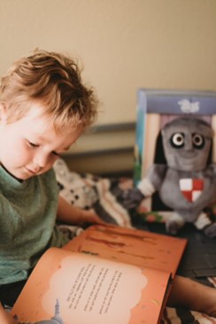 A child with a personalised milestone book from Hooray Heroes.