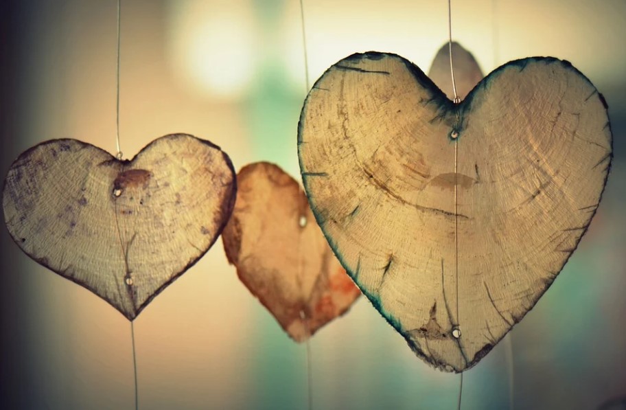 Three wooden Valentine's Day heart decorations. 
