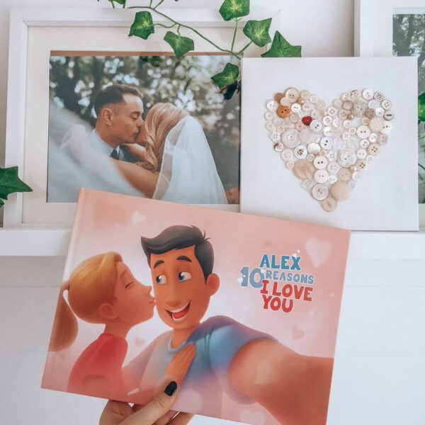 A woman holding a personalised Hooray Heroes book with a a heart and a wedding photo in the background.