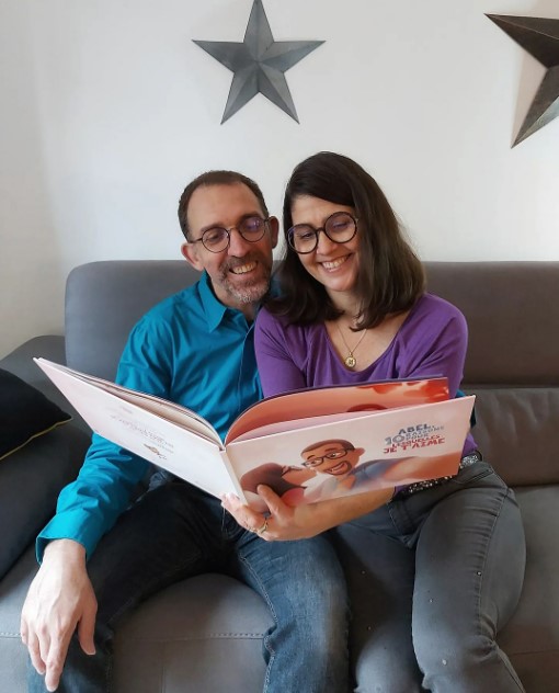 A couple enjoying the French version of a Hooray Heroes personalised love book.