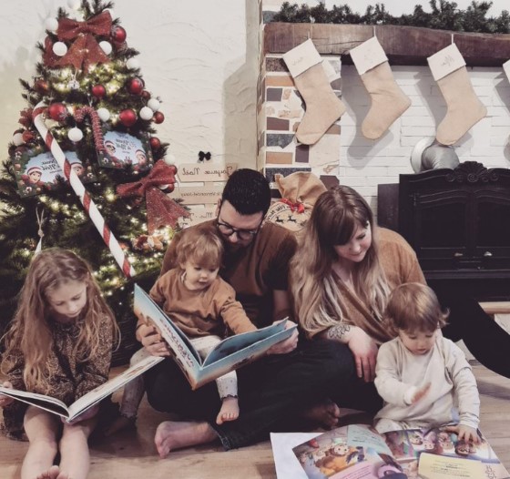 A family sitting next to the Christmas tree, reading their very own personalized books, the best xmas gift.